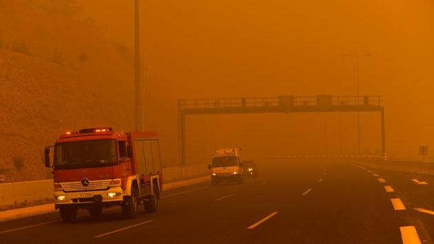 A fire fighting truck is seen amid smoke in Kineta. Officials raised the possibility the blazes could have been started deliberately by criminals out to ransack abandoned homes. (Angelos Tzortzinis / AFP) A fire fighting truck is seen amid smoke in Kineta. Officials raised the possibility the blazes could have been started deliberately by criminals out to ransack abandoned homes. (Angelos Tzortzinis / AFP)