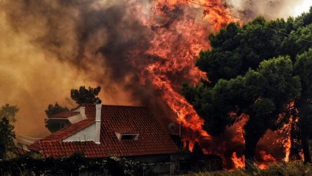 A house stands threatened by a huge blaze during a wildfire in Kineta. Two main fires broke out Monday, one to the west of Athens near the town of Kineta and one to the northeast near the port of Rafina. Both were fanned by gale-forced winds that hampered firefighting efforts. (Valerie Gache / AFP) A house stands threatened by a huge blaze during a wildfire in Kineta. Two main fires broke out Monday, one to the west of Athens near the town of Kineta and one to the northeast near the port of Rafina. Both were fanned by gale-forced winds that hampered firefighting efforts. (Valerie Gache / AFP)