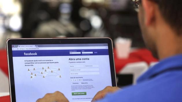 A man enters his Facebook page at a restaurant in Brasilia, Brazil.(AP)