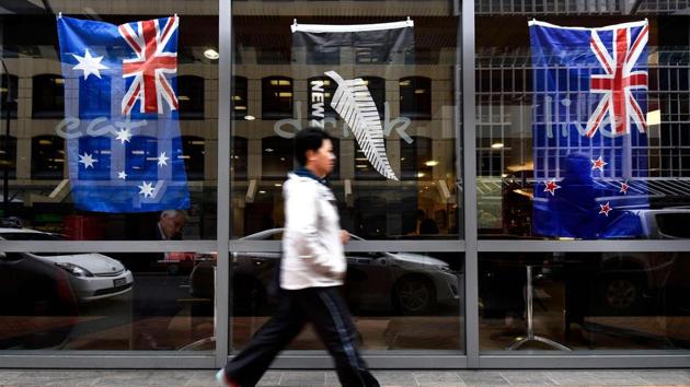 File photo shows a pedestrian walking past a bar window displaying New Zealand's national flag (right) and Australia's national flag (left) in Wellington. (AFP photo) File photo shows a pedestrian walking past a bar window displaying New Zealand's national flag (right) and Australia's national flag (left) in Wellington. (AFP photo)