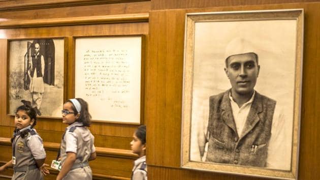 Children walk past a photograph of Jawaharlal Nehru at the Nehru Memorial Museum in Delhi.(HT file photo)