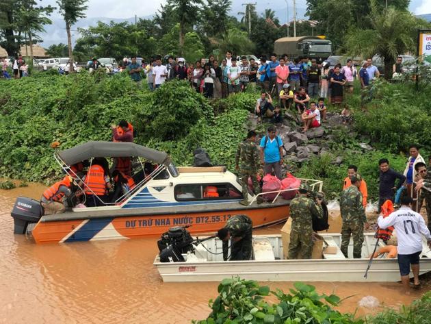 The search for survivors was hampered by monsoon weather. Boats and helicopters were dispatched to find people still trapped. Around a dozen Chinese rescuers in helmets and life jackets joined rescuers in Sanamxai town Thursday near the dam site. (Mime Phoumsavanh / REUTERS) 