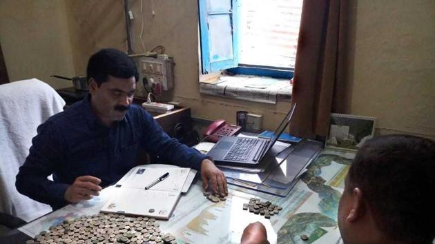 The pot, containing 329 coins weighing nearly four kg, was found when the ground was being dug to construct the main gate for the Bhairav Temple in the village. (HT Photo)