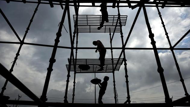 Monsoon clouds fill the sky as labourers standing on scaffoldings work to construct a hospital building in Greater Noida, Uttar Pradesh on July 23, 2018. (R S Iyer / AP) Monsoon clouds fill the sky as labourers standing on scaffoldings work to construct a hospital building in Greater Noida, Uttar Pradesh on July 23, 2018. (R S Iyer / AP)