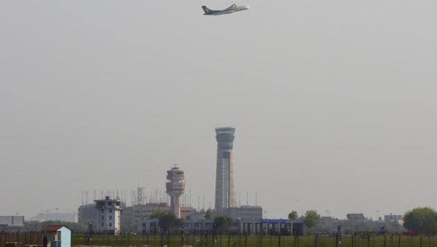 A passenger aircraft is seen flying over new ATC Tower at Terminal 3 of Indira Gandhi International Airport in New Delhi.(Vipin Kumar/HT File Photo)