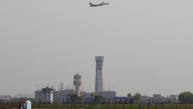 A passenger aircraft is seen flying over new ATC Tower at Terminal 3 of Indira Gandhi International Airport in New Delhi.(Vipin Kumar/HT File Photo)