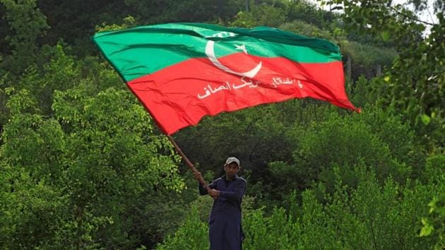 A supporter of cricket star-turned-politician Imran Khan, chairman of Pakistan Tehreek-e-Insaf (PTI), waves a party flag as he celebrates outside his residence in Islamabad, Pakistan, a day after polling in the general election. (Reuters Photo)
