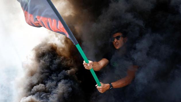 A protester waves a flag of the "Plataforma Caracol" taxi association during a strike by taxi drivers in Barcelona on July 25, 2018. (Pau Barrena / AFP) A protester waves a flag of the "Plataforma Caracol" taxi association during a strike by taxi drivers in Barcelona on July 25, 2018. (Pau Barrena / AFP)
