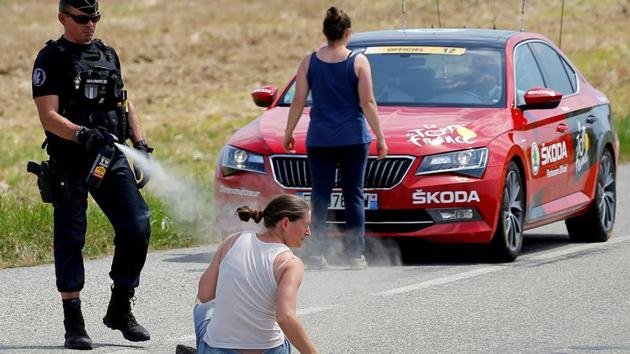 A police officer pepper sprays a protester as another protester stands in front of the race director's car during Stage 16 from Carcassonne to Bagneres-de-Luchon of Tour de France on July 24, 2018. (Stephane Mahe / REUTERS) A police officer pepper sprays a protester as another protester stands in front of the race director's car during Stage 16 from Carcassonne to Bagneres-de-Luchon of Tour de France on July 24, 2018. (Stephane Mahe / REUTERS)