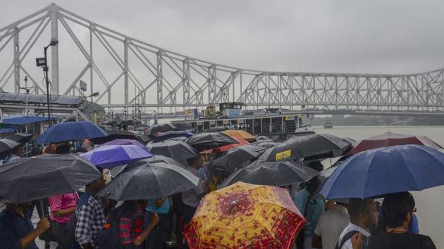 Passengers holding umbrellas wait for a ferry during rainfall, at a ghat in Kolkata, West Bengal on July 26, 2018. (PTI) Passengers holding umbrellas wait for a ferry during rainfall, at a ghat in Kolkata, West Bengal on July 26, 2018. (PTI)