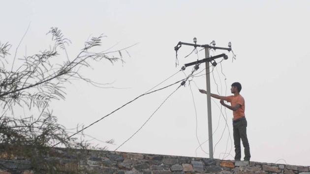 A man fiddles with a power line. (HT File Photo) A man fiddles with a power line. (HT File Photo)