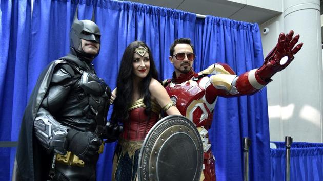 Fans dressed as Batman (left), Wonder Woman (centre), and Iron Man (right) attend day one of Comic-Con International, San Diego, July 19, 2018 (Chris Pizzello/Invision/AP) Fans dressed as Batman (left), Wonder Woman (centre), and Iron Man (right) attend day one of Comic-Con International, San Diego, July 19, 2018 (Chris Pizzello/Invision/AP)
