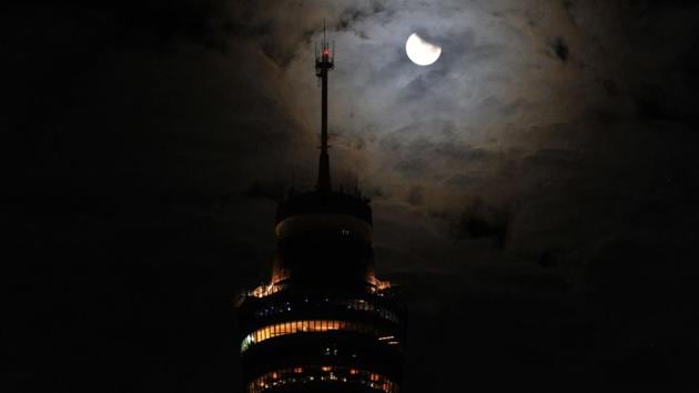 Earth's shadow covers the moon for the total lunar eclipse in Sydney. A total lunar eclipse happens when Earth takes position in a straight line between the moon and sun, blotting out the direct sunlight that normally makes our satellite glow whitish-yellow. (Saeed Khan / AFP)