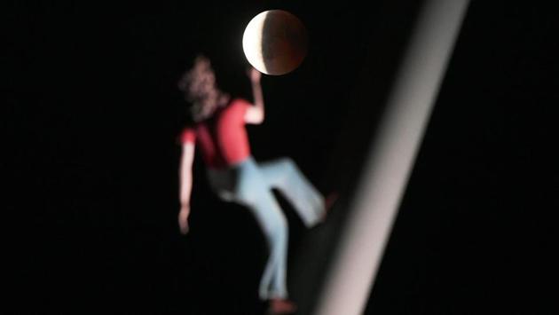The blood moon eclipse is pictured with a sculpture by the American artist Jonathan Borofsky "Woman walking to the sky" in Strasbourg, eastern France. (Fredrick Florin / AFP)