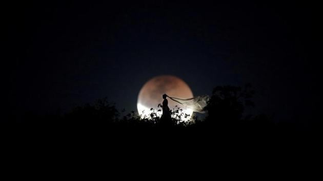 A bride poses for photo during the longest “blood moon” eclipse this century in Brasilia, Brazil. This eclipse coincided with Mars’ closest approach in 15 years to treat skygazers across the globe to a thrilling celestial spectacle. (Ueslei Marcelino / REUTERS)