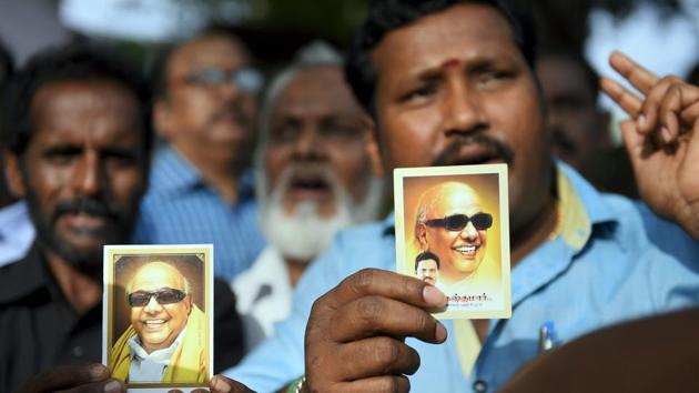 DMK supporters with portraits of party president M. Karunanidhi, wait outside a private hospital, where DMK Chief was admitted due to a sudden drop in blood pressure, in Chennai, on Saturday, July 28, 2018.(PTI Photo)