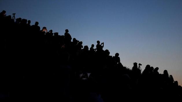 People watch the total lunar eclipse in the Olympic park in Munich, southern Germany. The next lunar eclipse of such a length is due in 2123. (Christof Stache / AFP)