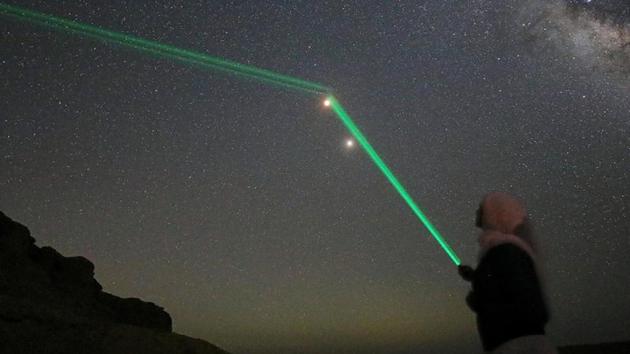 A woman shines laser light towards the Blood Moon at the desert of Al Fayoum Governorate, south west of Cairo, Egypt. (Mohamed Abd El Ghany / REUTERS)