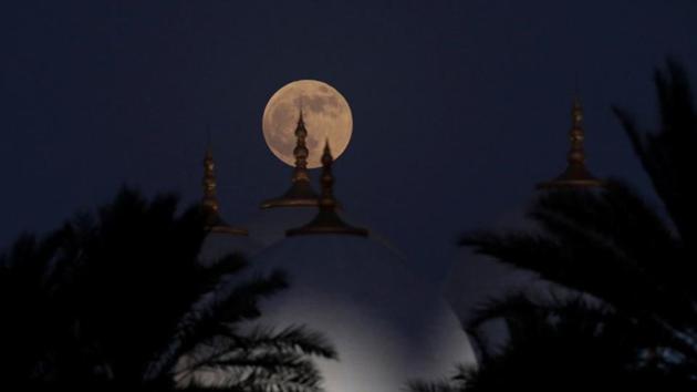 The lunar eclipse of the full Blood Moon rises behind the Sheikh Zayed Grand Mosque in Abu Dhabi, United Arab Emirates. “It is a very unusual coincidence to have a total lunar eclipse and Mars at opposition on the same night,” said Robert Massey, deputy executive director of the Royal Astronomical Society, who watched the eclipse from the Mediterranean Sea. (Christopher Pike / REUTERS)