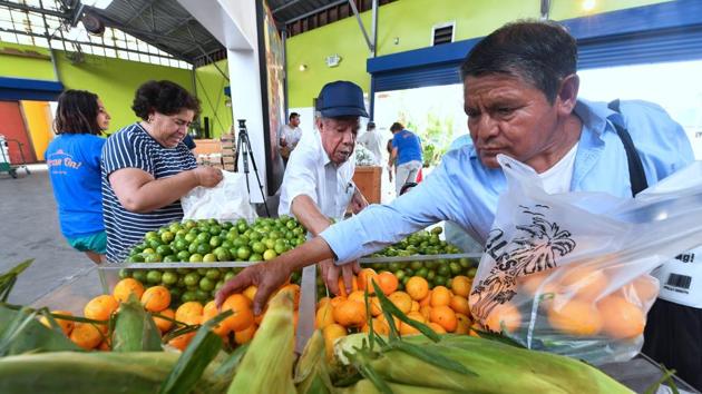Delighted to take home food that others would discard, people look eagerly over the bounty of fresh produce spread out before them. On this particular day, a non-governmental organization called Food Forward and a community center distributed 6,800 kilos of fruit and vegetables that wholesalers would otherwise have thrown out. (Frederic J. Brown / AFP) Delighted to take home food that others would discard, people look eagerly over the bounty of fresh produce spread out before them. On this particular day, a non-governmental organization called Food Forward and a community center distributed 6,800 kilos of fruit and vegetables that wholesalers would otherwise have thrown out. (Frederic J. Brown / AFP)