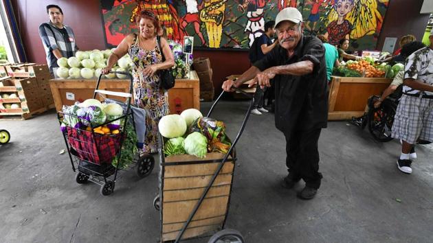 People pick their free fruit and vegetables on offer during a twice monthly food distribution effort in the Watts neighborhood of south Los Angeles, California. The NGO Food Forward is working to salvage food that Americans throw away every year and give it to the needy. The center also helps people find work, and offers assistance to young people applying to college. (Frederic J. Brown / AFP) People pick their free fruit and vegetables on offer during a twice monthly food distribution effort in the Watts neighborhood of south Los Angeles, California. The NGO Food Forward is working to salvage food that Americans throw away every year and give it to the needy. The center also helps people find work, and offers assistance to young people applying to college. (Frederic J. Brown / AFP)