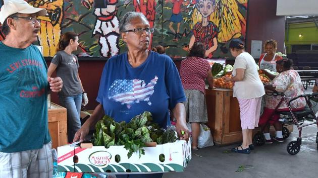 This particular twice-monthly handout is held in a warehouse in Watts, one of the poorest and roughest neighborhoods of Los Angeles, where most residents are black or Latino. “They can have two or more bags, and they fill up, and there is no restrictions,” said Sheila Thomas, who works for the community center allied with Food Forward at this warehouse. (Frederic J. Brown / AFP) This particular twice-monthly handout is held in a warehouse in Watts, one of the poorest and roughest neighborhoods of Los Angeles, where most residents are black or Latino. “They can have two or more bags, and they fill up, and there is no restrictions,” said Sheila Thomas, who works for the community center allied with Food Forward at this warehouse. (Frederic J. Brown / AFP)