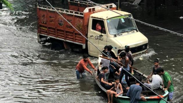 People commute on a boat as Goolar Road inundated due to heavy rains in Aligarh, Uttar Pradesh. (HT Photo) People commute on a boat as Goolar Road inundated due to heavy rains in Aligarh, Uttar Pradesh. (HT Photo)