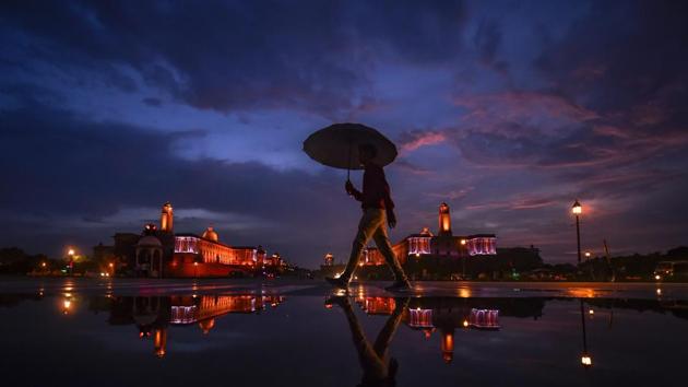 A man walks after light monsoon rainfall at Vijay Chowk in New Delhi on Saturday, July 28, 2018. (PTI Photo) A man walks after light monsoon rainfall at Vijay Chowk in New Delhi on Saturday, July 28, 2018. (PTI Photo)