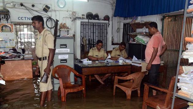Police personnel carry out their duty as police station gets waterlogged after monsoon rains at North 24 Parganas, West Bengal. (PTI) Police personnel carry out their duty as police station gets waterlogged after monsoon rains at North 24 Parganas, West Bengal. (PTI)