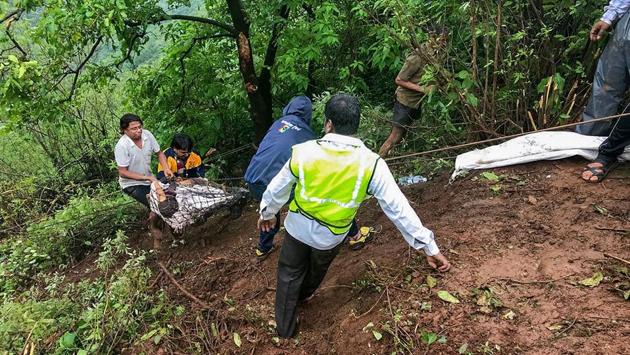 Mahabaleshwar trekker members take out bodies at the accident site where a bus carrying a group of staff members of an agriculture university, fell into a 500-ft gorge in the Konkan region, killing 33 passengers, in Raigad on Saturday. (PTI)