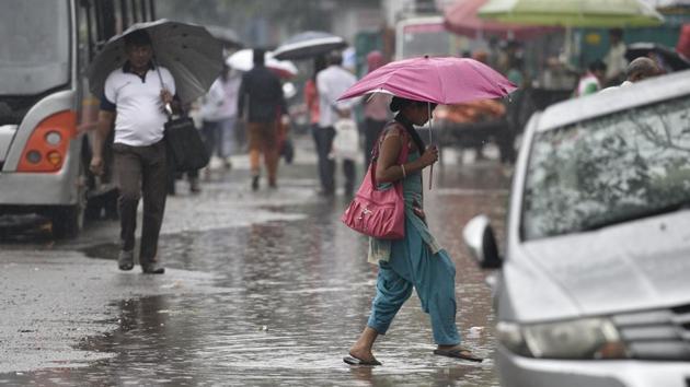 Commuters holding umbrellas as they walk during rain in New Delhi on July 27.(Sanchit Khanna/HT PHOTO)