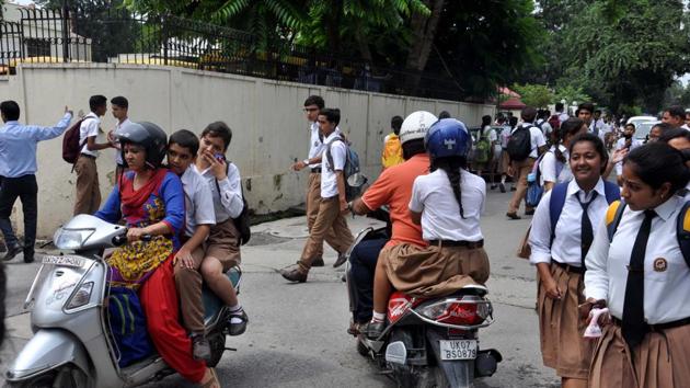 Parents carry their children from school in Dehradun on Monday. (Vinay Santosh Kumar /HT Photo) Parents carry their children from school in Dehradun on Monday. (Vinay Santosh Kumar /HT Photo)