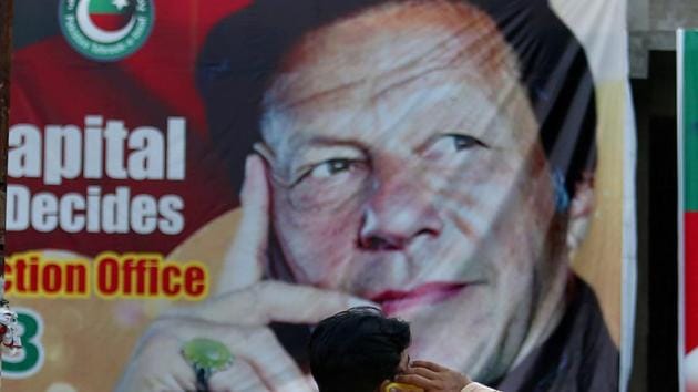 A Pakistani talks on his cell phone while he sits on a bench next to a big poster of Imran Khan, head of Pakistan Tehreek-e-Insaf party, at a market in Islamabad, Pakistan, Saturday, July 28, 2018. Khan is set to take oath as Pakistan’s prime minister after his party emerged as the single largest party in the National Assembly in July 25 elections. (AP) A Pakistani talks on his cell phone while he sits on a bench next to a big poster of Imran Khan, head of Pakistan Tehreek-e-Insaf party, at a market in Islamabad, Pakistan, Saturday, July 28, 2018. Khan is set to take oath as Pakistan’s prime minister after his party emerged as the single largest party in the National Assembly in July 25 elections. (AP)