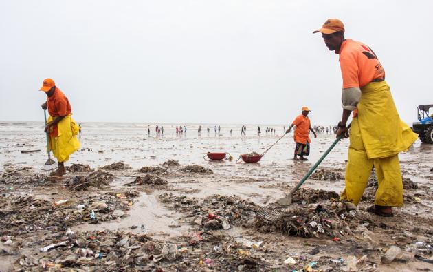 Municipal workers clean plastic waste on Juhu beach.(HT PHOTO)