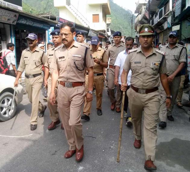 Police conduct a flag march after at Ghansali in Uttarkhand’s Tehri Garhwal district. A mob of nearly 250 people thrashed 18-year-old Azad Alvi on Monday after he was caught with a minor Hindus girl inside a hotel in Ghansali town market, and paraded him with a garland of shoes around his neck. They also ransacked 13 shops of Muslim traders in the market.(HT Photo)