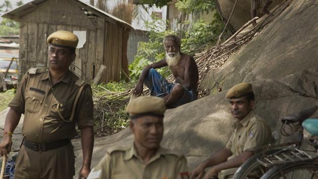 A man sits near security personnel as he arrives to check if his name is included in the National Register of Citizens at a draft center in Mayoung. As the controversy over denying citizenship to 40 lakh applicants brewed, the central government urged people not to panic and asked the opposition not to politicise the issue. (Anupam Nath / AP)