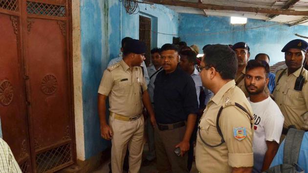 Policemen and residents stand outside the entrance door of a building were seven members of a family were found hanging, in Ranchi on July 30, 2018.(AFP) Policemen and residents stand outside the entrance door of a building were seven members of a family were found hanging, in Ranchi on July 30, 2018.(AFP)