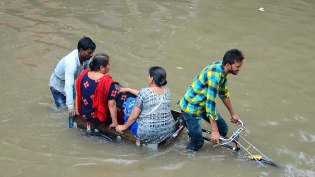Indian women are transported on a bicycle cart on a flooded road following heavy rain in Mathura in Uttar Pradesh state on July 26, 2018. (AFP) Indian women are transported on a bicycle cart on a flooded road following heavy rain in Mathura in Uttar Pradesh state on July 26, 2018. (AFP)