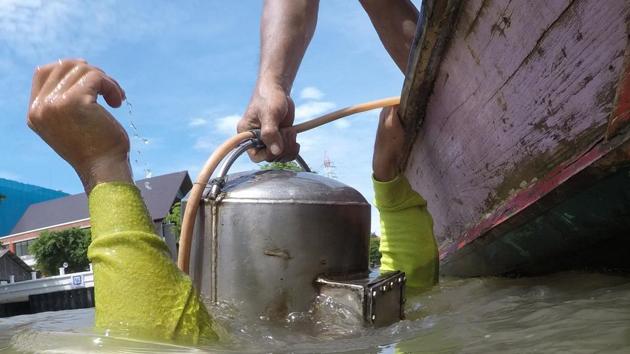 The “Indiana Jones” divers use makeshift equipment and operate under the radar in the middle of the country’s urban metropolis. Wearing shorts and T-shirt, they jump off the motorised skiff into a river strewn with city sewage and debris. The boxy helmet that weighs around 20 kilos, and is hooked up to a rubber tube that connects to an air tank aboard the boat, keeps oxygen flowing into their body. (Sippachai Kunnuwong / AFP)