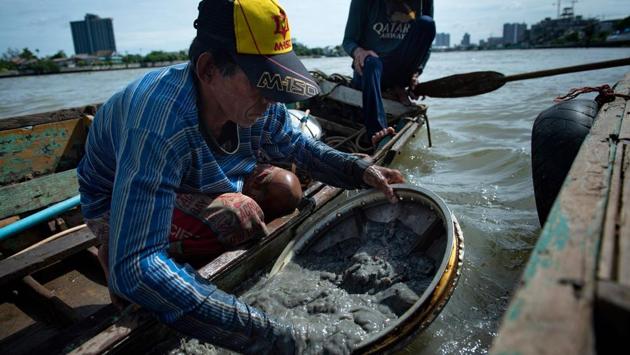 The coins trace the history of the Thai capital’s lively waterfront, whose traditional stilted homes are increasingly being knocked down for development. “In the old days, we lived on rafts and had floating markets. Villagers lost their jewellery and money in the river,” said Bhoomin. (Sippachai Kunnuwong / AFP)