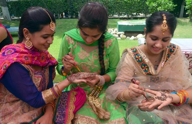 As part of the ritual, young girls and married women apply mehendi or henna tattoos. (Sameer Sehgal/ht)