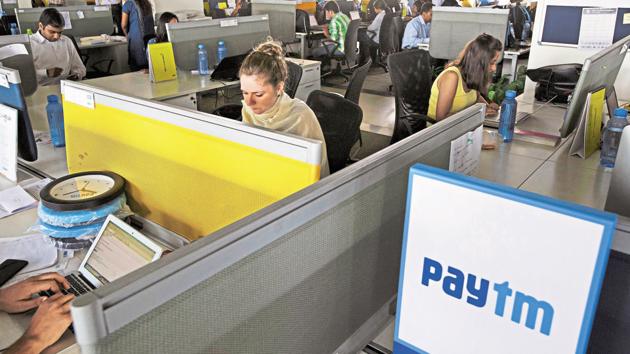 Employees work at their desks at the One97 Communications Ltd. headquarters in Noida, Uttar Pradesh, India, on Thursday, May 14, 2015. One97, which operates PayTM, think they have an edge as the country is now in the midst of a smartphone boom, and younger Indians are shunning branches and turning to apps for their banking needs, mirroring global trends. Photographer: Kuni Takahashi/Bloomberg(Bloomberg)