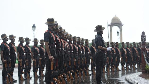 An army soldiers standing under the India Gate war memorial