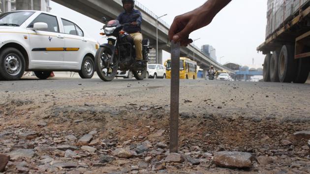 A pothole at Genpact Chowk, one of the many key junctions of Gurugram, that not only slows down traffic but also pose risks to commuters. (Yogendra Kumar/HT PHOTO) A pothole at Genpact Chowk, one of the many key junctions of Gurugram, that not only slows down traffic but also pose risks to commuters. (Yogendra Kumar/HT PHOTO)