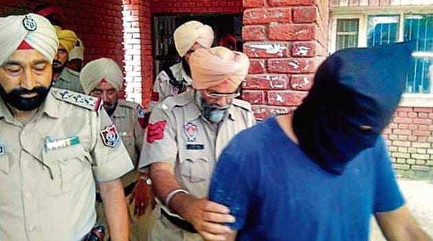 Police taking a Dera Sacha Sauda follower accused of sacrilege to a Moga court. (HT file) Police taking a Dera Sacha Sauda follower accused of sacrilege to a Moga court. (HT file)