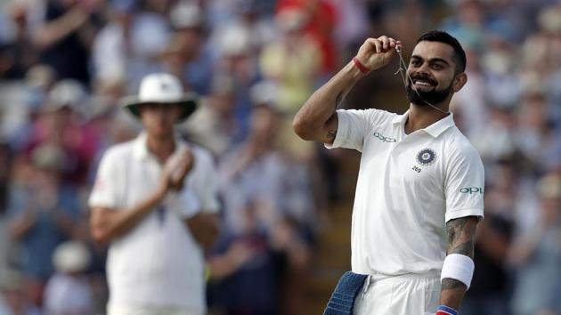 India's captain Virat Kohli holds his wedding ring as he celebrates scoring his century on the second day of the first Test cricket match between England and India at Edgbaston in Birmingham.(AFP)