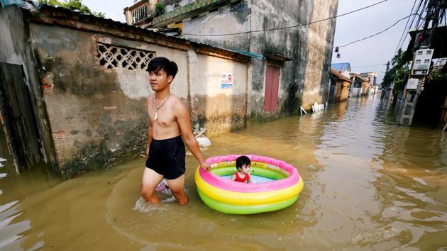 A man pulls an inflatable pool carrying his daughter on a flooded village after heavy rainfall caused by tropical storm Son Tinh outside Hanoi, Vietnam. (Kham / REUTERS) A man pulls an inflatable pool carrying his daughter on a flooded village after heavy rainfall caused by tropical storm Son Tinh outside Hanoi, Vietnam. (Kham / REUTERS)