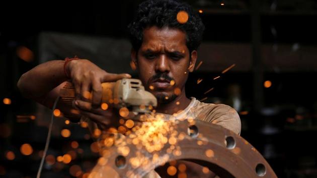 A man uses a disc grinder as he smoothens a flange ring at a workshop in an industrial area in Mumbai, Maharashtra on August 2, 2018. (Francis Mascarenhas / REUTERS) A man uses a disc grinder as he smoothens a flange ring at a workshop in an industrial area in Mumbai, Maharashtra on August 2, 2018. (Francis Mascarenhas / REUTERS)