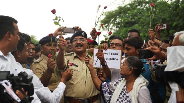 Senior Police officers receive roses from members of the Chhara community, who are originally listed under the Criminal Tribes Act of 1871, at Kubernagar Police Chowky on the outskirts of Ahmedabad, Gujarat following a dispute with policemen on July 27 that turned violent on July 29, 2018. (Sam Panthaky / AFP) Senior Police officers receive roses from members of the Chhara community, who are originally listed under the Criminal Tribes Act of 1871, at Kubernagar Police Chowky on the outskirts of Ahmedabad, Gujarat following a dispute with policemen on July 27 that turned violent on July 29, 2018. (Sam Panthaky / AFP)