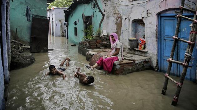 Boys play in flood waters outside their submerged home by the banks of the Yamuna in New Delhi on July 31, 2018. (Altaf Qadri / AP) Boys play in flood waters outside their submerged home by the banks of the Yamuna in New Delhi on July 31, 2018. (Altaf Qadri / AP)